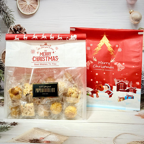 A set of assorted Christmas-themed cookies, with individual packaging visible. The packaging is predominantly red with snowflake and Christmas motifs, indicating a festive holiday gift.